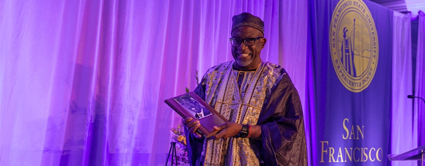 Vincent Matthews proudly holds his plaque  at the alumni Hall of Fame 